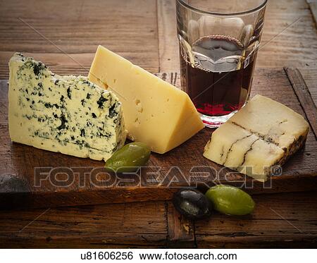Stock Photograph - Assorted cheeses with olives and red wine. Fotosearch