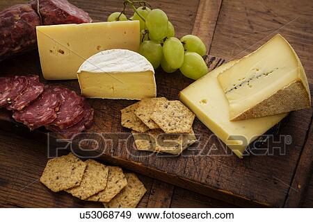 Assorted cheeses with salami and grapes View Large Photo Image Stock Photo - Assorted cheeses with salami and grapes. Fotosearch