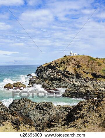 Stock Photo - Australia, New South Wales, Cliff and lighthouse in background. Fotosearch