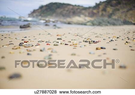 Stock Photo - Australia, New South Wales, Colorful stones on sandy beach. Fotosearch
