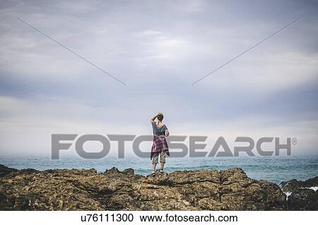 Australia, New South Wales, Woman standing on cliff and looking at view View Large Photo Image Stock Image - Australia, New South Wales, Woman standing on cliff and looking at view. Fotosearch