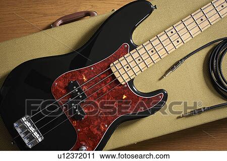 Bass guitar and cable lying on guitar case View Large Photo Image Stock Image - Bass guitar and cable lying on guitar case. Fotosearch