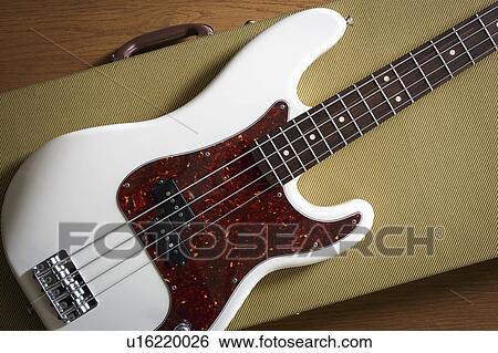 Stock Photograph - Bass guitar lying on guitar case. Fotosearch