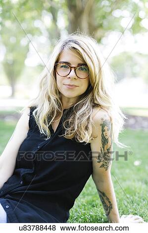 Stock Photo - Blonde woman sitting on grass. Fotosearch
