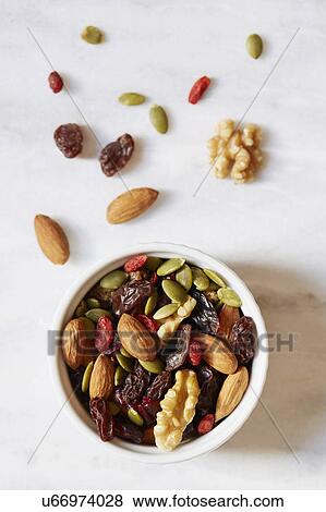 Stock Photo - Bowl of nuts and raisins on white background. Fotosearch