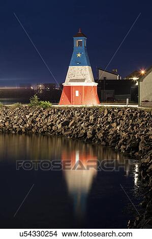 Picture - Canada, Nova Scotia, Cheticamp, Lighthouse reflecting in water. Fotosearch