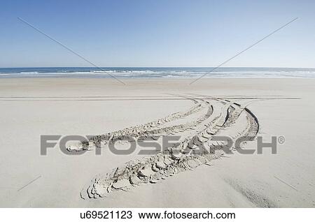 Stock Image - Car tire trail on sand. Fotosearch