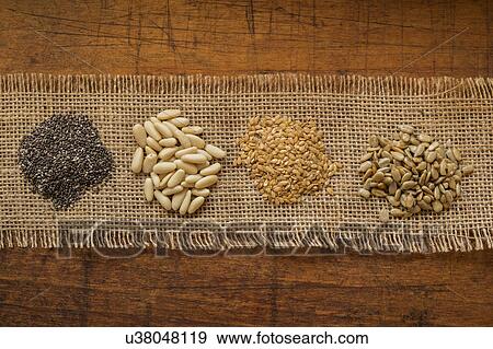 Stock Photo - Chia seeds, pine nuts, flax seeds and sunflower seeds. Fotosearch