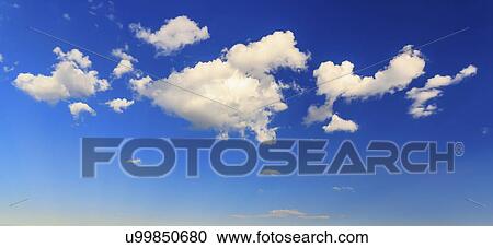 Stock Image - Fluffy clouds in blue sky. Fotosearch