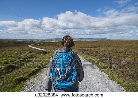 Picture - Ireland, Cavan County, Cuilcagh Mountain Park, Woman hiking along road. Fotosearch