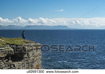 Ireland, Donegal County, Muckross Head, Woman standing on top of cliff View Large Photo Image Stock Image - Ireland, Donegal County, Muckross Head, Woman standing on top of cliff. Fotosearch