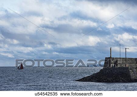 Stock Photography - Ireland, Galway County, Spiddal, Hooker sailboat and pier. Fotosearch
