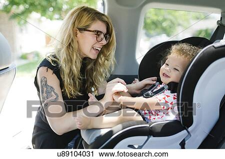 Stock Image - Mother and daughter (12-17 months) in car. Fotosearch
