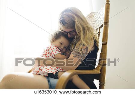 Mother sitting on chair and rocking daughter (12-17 months) View Large Photo Image Stock Image - Mother sitting on chair and rocking daughter (12-17 months). Fotosearch