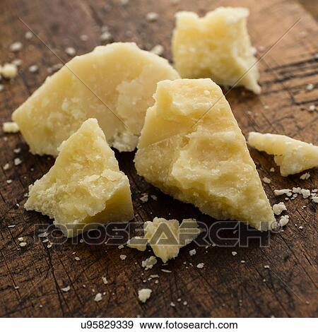 Stock Photo - Parmesan cheese on wooden table. Fotosearch