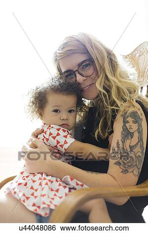 Portrait of mother and daughter (12-17) sitting on chair View Large Photo Image Stock Photograph - Portrait of mother and daughter (12-17) sitting on chair. Fotosearch