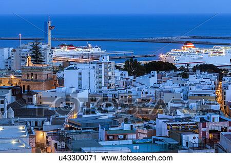 Stock Image - Spain, Andalusia, Almeria, Cityscape with sea at dusk. Fotosearch