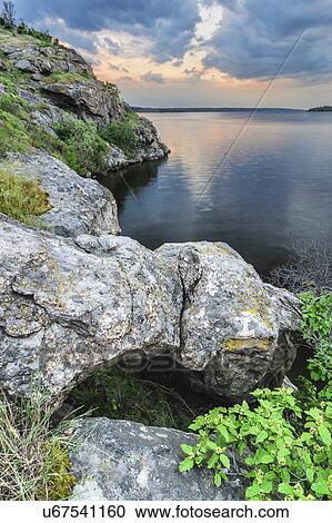 Stock Image - Ukraine, Dnepropetrovsk Region, Dnepropetrovsk District, Voloske, Rocky shore of lake at dawn. Fotosearch
