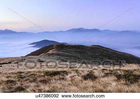 Stock Image - Ukraine, Zakarpattia region, Rakhiv district, Carpathians, Chornohora, Sheshul, Mist over mountains at dawn. Fotosearch