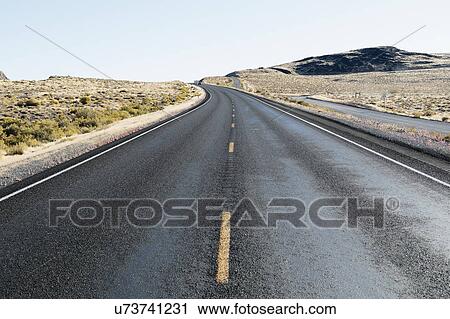 Stock Image - USA, Nevada, Highway 50, Blue sky over empty road. Fotosearch