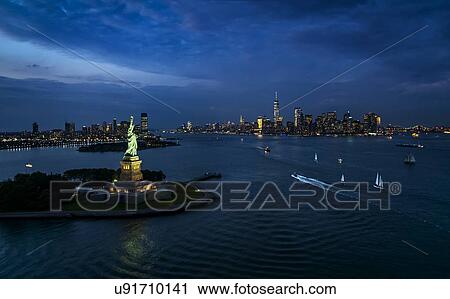 Stock Image - USA, New York, New York City, Statue of liberty at night. Fotosearch