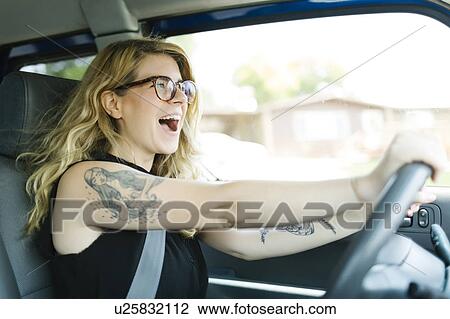 Woman driving car and laughing View Large Photo Image Stock Image - Woman driving car and laughing. Fotosearch