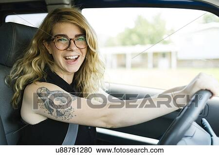 Stock Image - Woman driving car and laughing. Fotosearch
