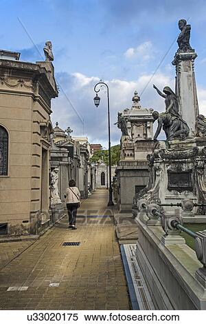 Stock Photography - Argentina, Buenos Aires, Woman walking through Recoleta Cemetery. Fotosearch