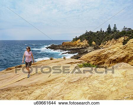 Australia, New South Wales, Bermagui, Woman walking on coast View Large Photo Image Picture - Australia, New South Wales, Bermagui, Woman walking on coast. Fotosearch