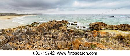 Stock Image - Australia, New South Wales, Bournda National Park, Rocky seashore with overcast sky. Fotosearch