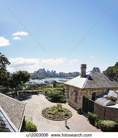 Stock Photograph - Australia, New South Wales, Sydney, Courtyard of house with city skyline in background. Fotosearch