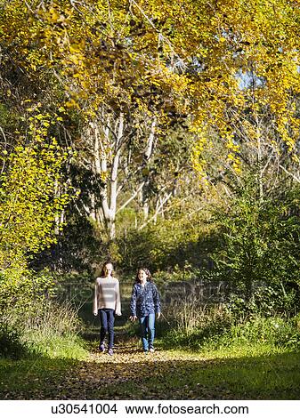 Picture - Australia, Queensland, Girls (10-11, 12-13) walking on footpath at autumn. Fotosearch