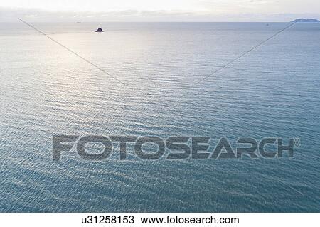 Stock Image - Australia, Queensland, Sea reflecting sunlight. Fotosearch