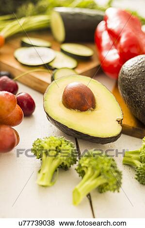 Stock Photo - Avocado surrounded by various fruits and vegetables. Fotosearch