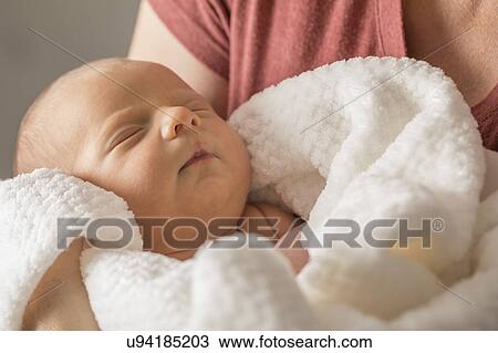 Stock Image - Baby boy (0-1 months) in mothers arms. Fotosearch