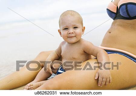 Baby boy (12-17 months) sitting between legs of her mother View Large Photo Image Stock Image - Baby boy (12-17 months) sitting between legs of her mother. Fotosearch