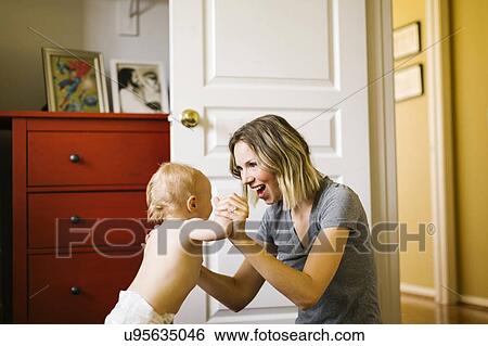 Baby boy (12-17 months) taking first steps with mother View Large Photo Image Stock Photograph - Baby boy (12-17 months) taking first steps with mother. Fotosearch