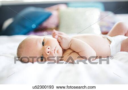 Baby boy (2-5 months) lying in bed View Large Photo Image Stock Image - Baby boy (2-5 months) lying in bed. Fotosearch