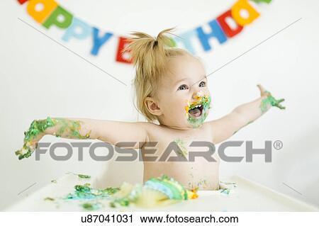 Stock Image - Baby girl (12-17 months) celebrating first birthday. Fotosearch