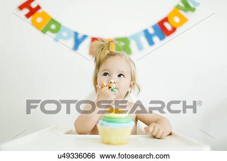 Stock Photograph - Baby girl (12-17 months) celebrating first birthday. Fotosearch