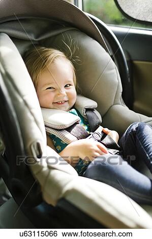 Baby girl (12-17 months) sitting in baby car seat during car trip View Large Photo Image Stock Photograph - Baby girl (12-17 months) sitting in baby car seat during car trip. Fotosearch