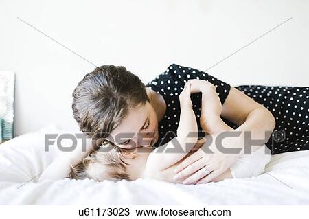 Baby girl (6-11 Months) being hugged by mother View Large Photo Image Stock Image - Baby girl (6-11 Months) being hugged by mother. Fotosearch