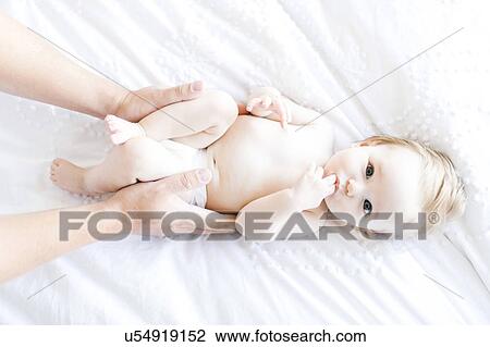 Baby girl (6-11 Months) lying down with finger in mouth while father holding her, directly above View Large Photo Image Stock Image - Baby girl (6-11 Months) lying down with finger in mouth while father holding her, directly above. Fotosearch