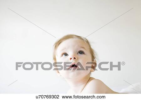 Stock Image - Baby girl (6-11 months) playing in bedroom. Fotosearch