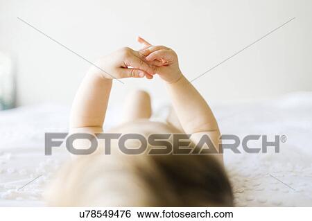 Stock Photograph - Baby girl (6-11 months) playing in bedroom. Fotosearch