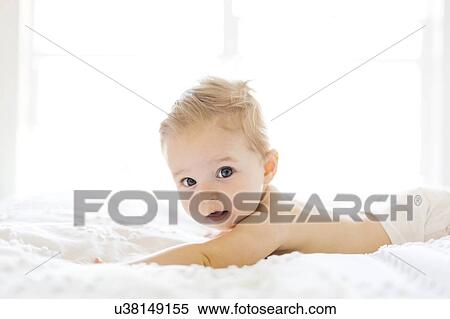 Stock Photography - Baby girl (6-11 months) playing in bedroom. Fotosearch