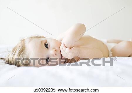 Stock Photography - Baby girl (6-11 months) playing in bedroom. Fotosearch