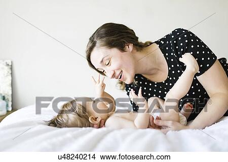 Picture - Baby girl (6-11 Months) playing with mother. Fotosearch