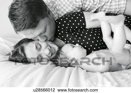 Baby girl (6-11 Months) spending time with parents View Large Photo Image Stock Image - Baby girl (6-11 Months) spending time with parents. Fotosearch