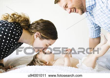 Baby girl (6-11 Months) spending time with parents View Large Photo Image Stock Image - Baby girl (6-11 Months) spending time with parents. Fotosearch